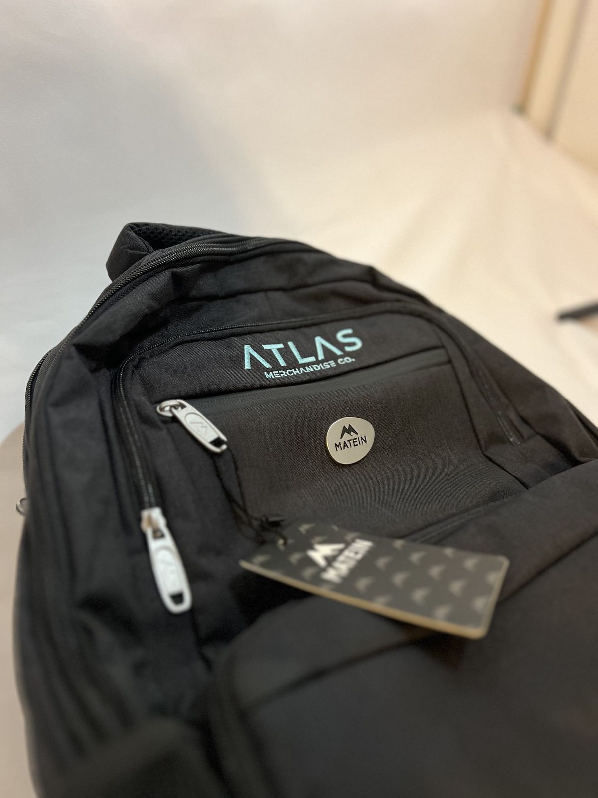 Black backpack branded with the Atlas Merchandise Co. logo